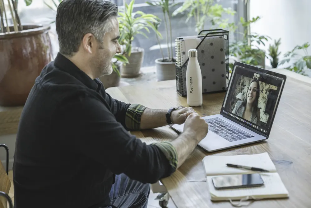 An advisor meets a client by video call from a sunlit office